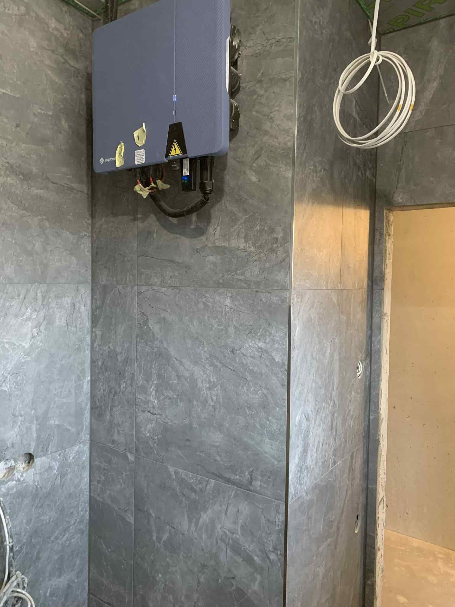 Techninės patalpos sienų apdaila didelio formato pilkomis plytelėmis
